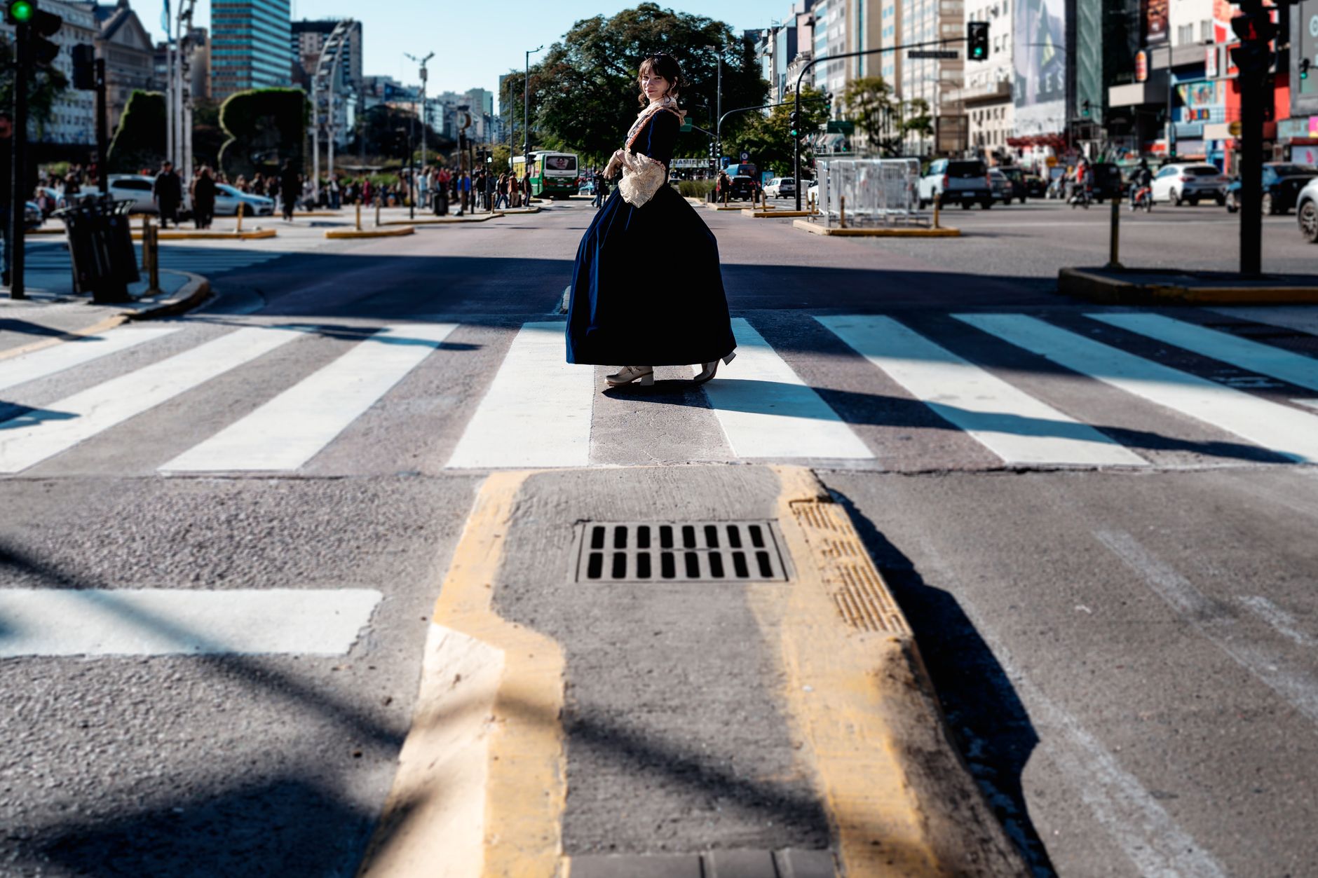 Woman in vintage attire crossing a city street in Buenos Aires. Urban, historic vibe.