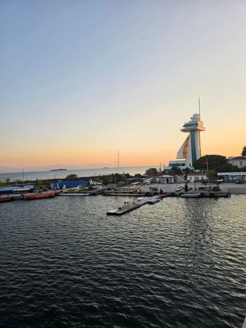 Free Sunset view of a marina in Istanbul with a modern lighthouse and calm waters, capturing the serene evening ambiance. Stock Photo