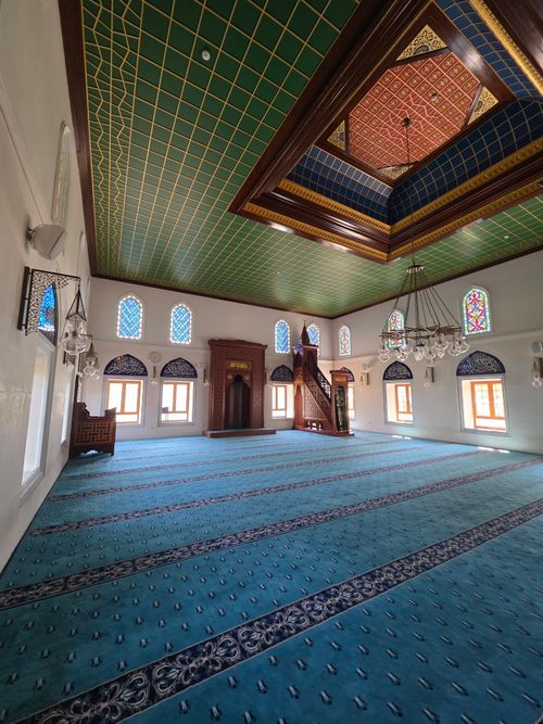 Free Explore the tranquil interior of an Istanbul mosque featuring beautiful geometric ceiling patterns and vibrant stained glass windows. Stock Photo