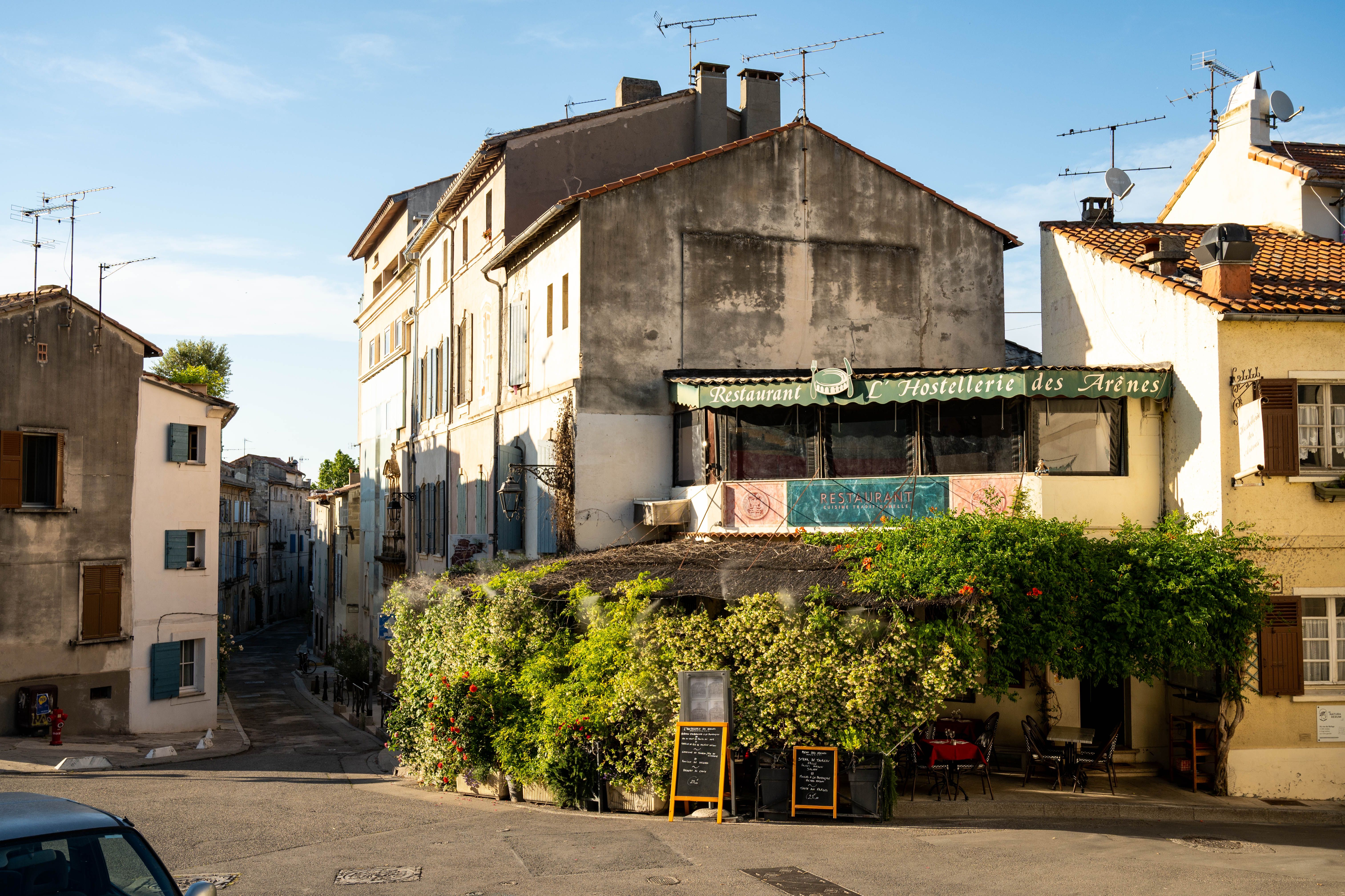Quaint street view in Arles, Provence showcasing traditional French architecture and cafe.