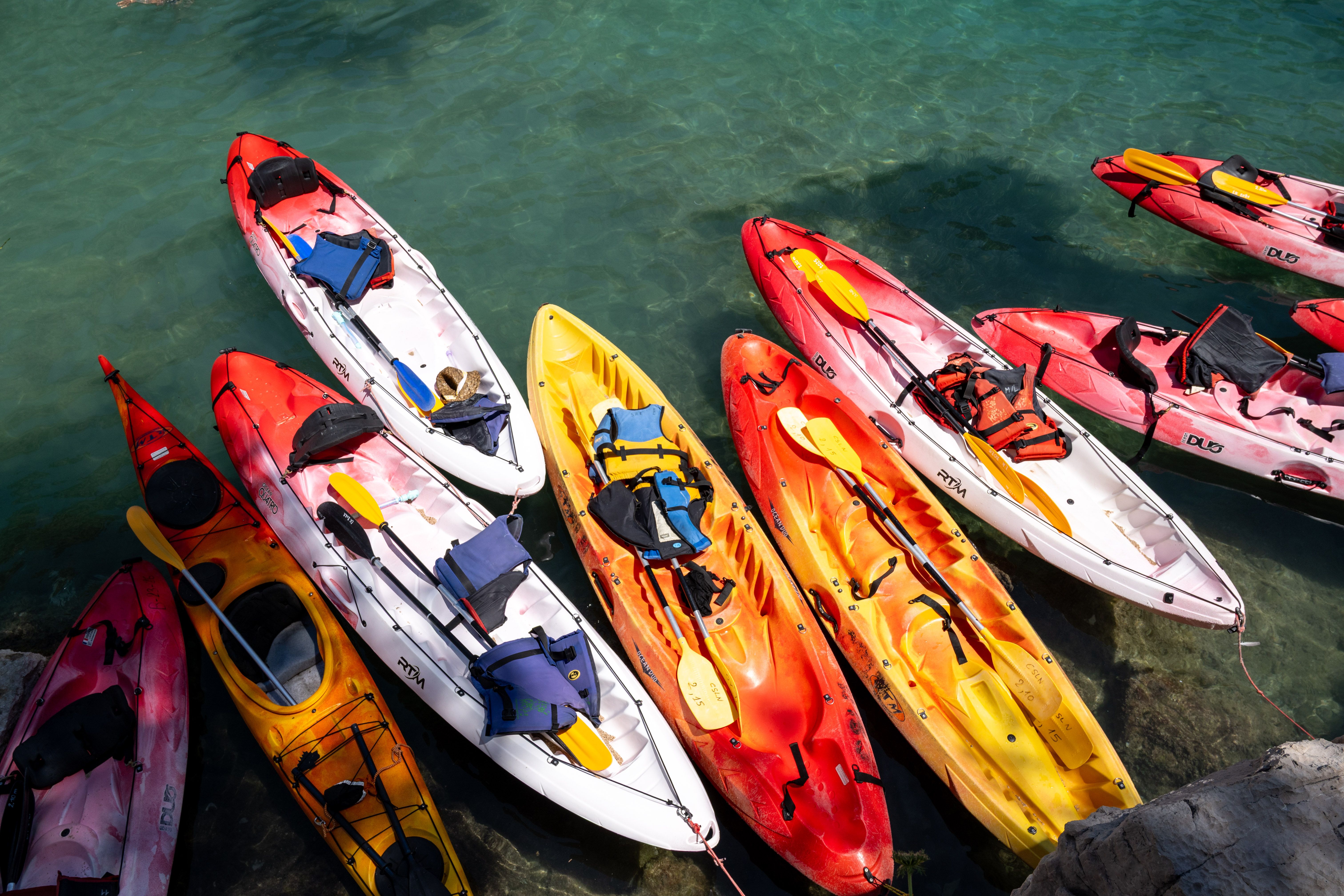 Colorful kayaks lined up at the crystal-clear waters of Marseille, perfect for a summer adventure.
