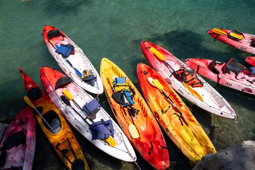 Free Colorful kayaks lined up at the crystal-clear waters of Marseille, perfect for a summer adventure. Stock Photo
