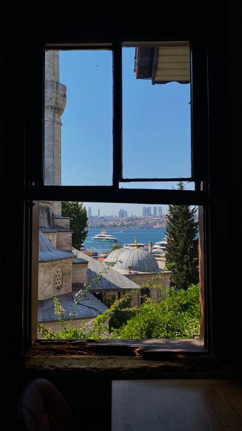 Free Captivating view of Istanbul from a historic window, featuring rooftops and the Bosphorus. Stock Photo