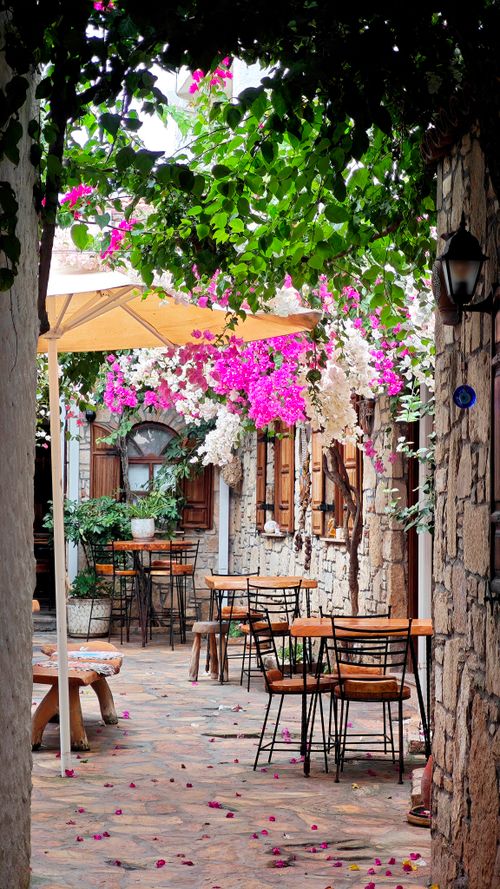 Free Cozy Mediterranean courtyard with vibrant bougainvillea and rustic decor, perfect for relaxation. Stock Photo