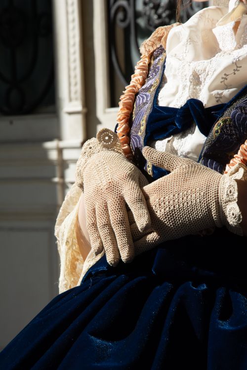 Free Close-up of a woman wearing lace gloves and a velvet dress, showcasing vintage fashion. Stock Photo