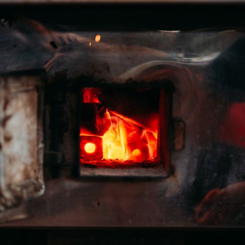 Free Detailed view of burning flames inside a metal furnace, showcasing intense heat and fire glow. Stock Photo