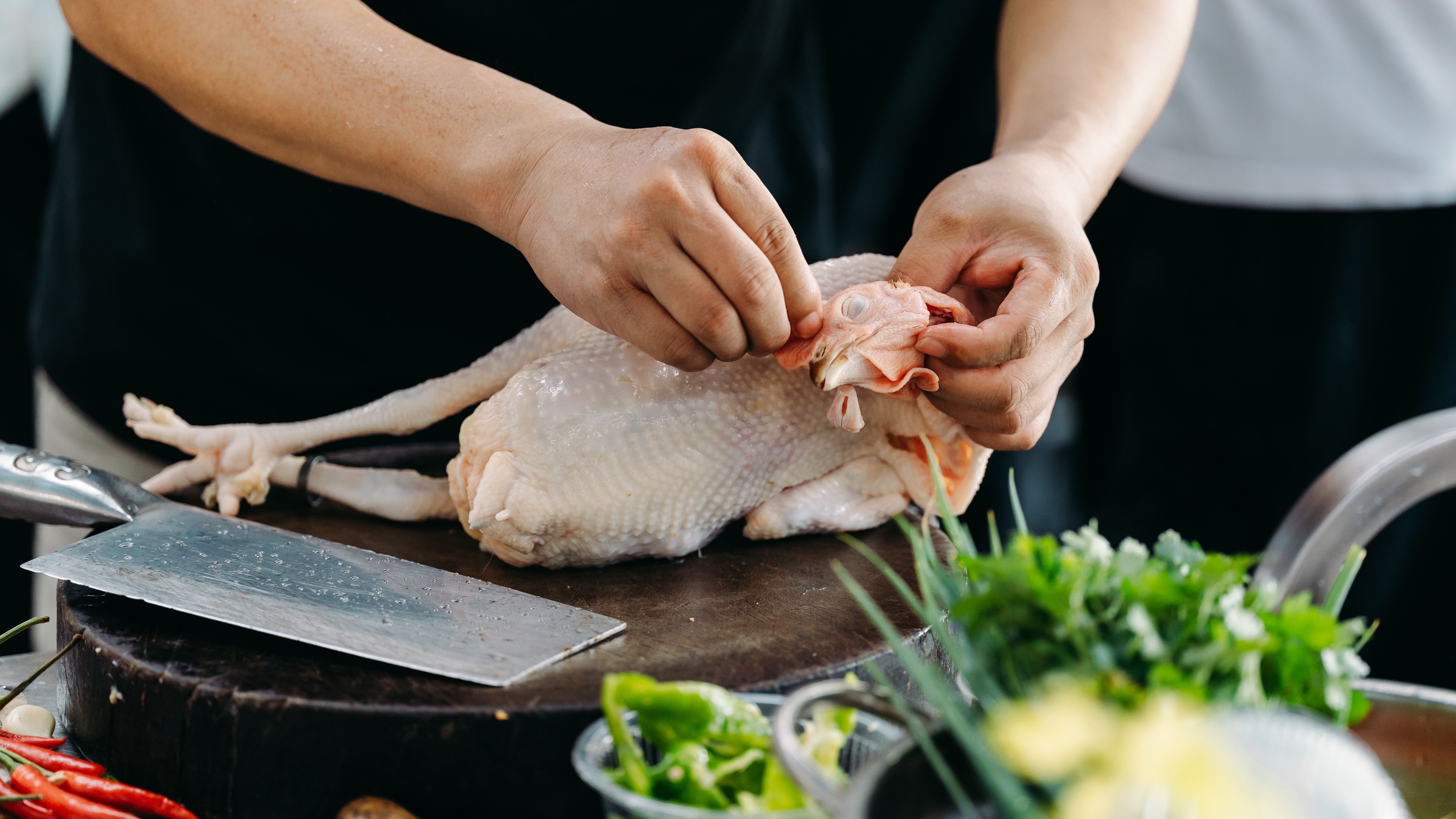 Woman meal prepping chicken and vegetables in a Dover kitchen