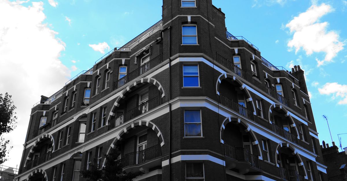 A modern building with prominent arches under a clear blue sky, capturing urban architecture.