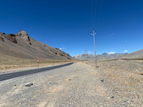 Free Desolate road through the rocky mountains of Leh under a clear blue sky. Stock Photo
