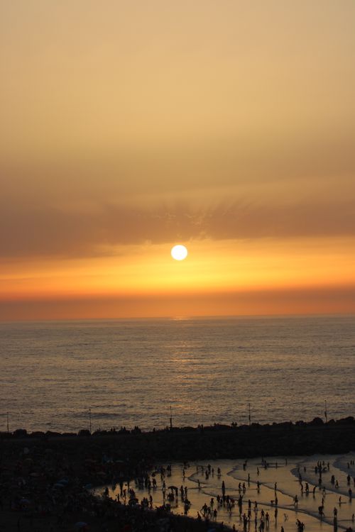 Free Stunning sunset view over Rabat beach with silhouettes of people enjoying the shore. Stock Photo