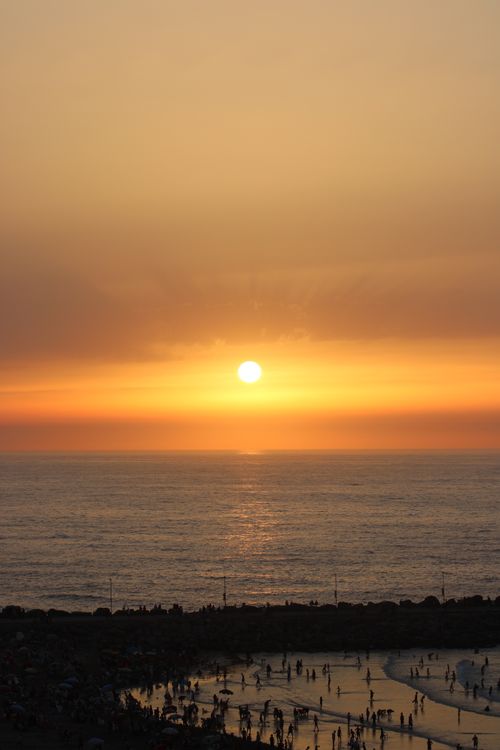 Free A breathtaking sunset view over the beach in Rabat, Morocco, with silhouettes of people enjoying the scene. Stock Photo