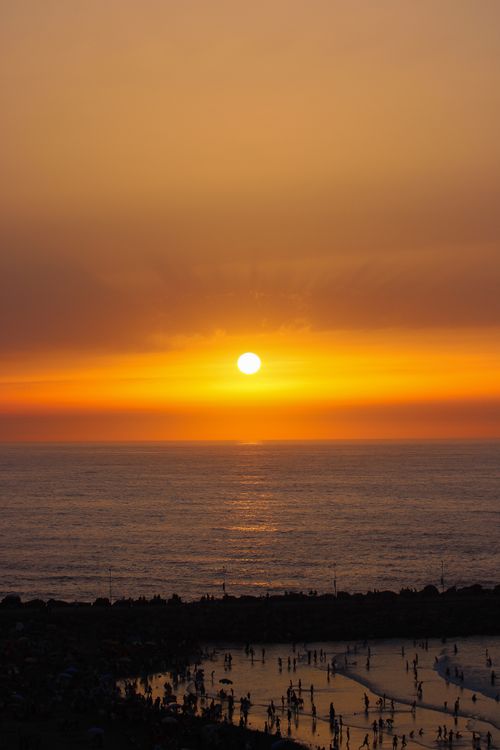 Free Stunning sunset over Rabat beach with silhouettes of people enjoying the coastline. Stock Photo
