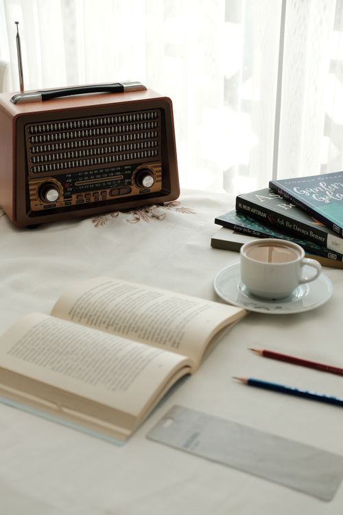 Free Warm, inviting reading corner featuring a vintage radio, books, and coffee. Stock Photo