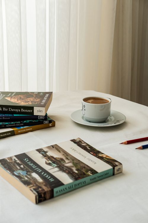 Free Cozy setup with books, coffee cup, and pencils on a table, ideal for study or leisure. Stock Photo