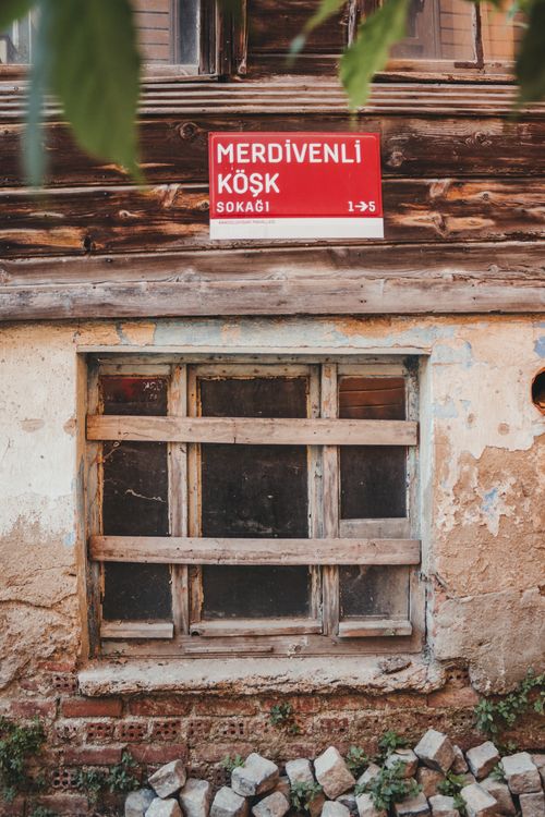 Free A rustic window on an old building with a Turkish street sign above it, creating a nostalgic vibe. Stock Photo