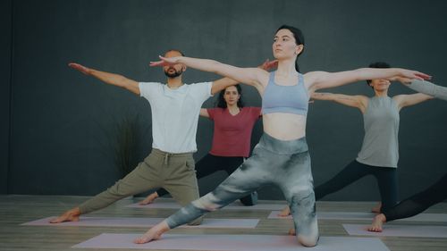 Free A group of adults practicing yoga indoors in a serene and focused setting. Stock Photo