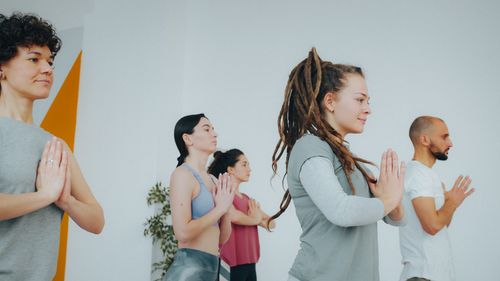 Free Diverse group of adults practicing yoga indoors, maintaining focus and calmness. Stock Photo