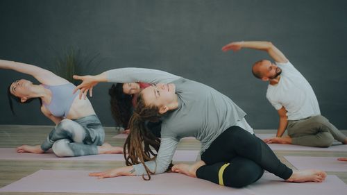 Free A diverse group of adults practicing yoga indoors, showcasing flexibility and mindfulness. Stock Photo