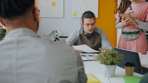 Young professionals engaged in a discussion at a modern workspace table.