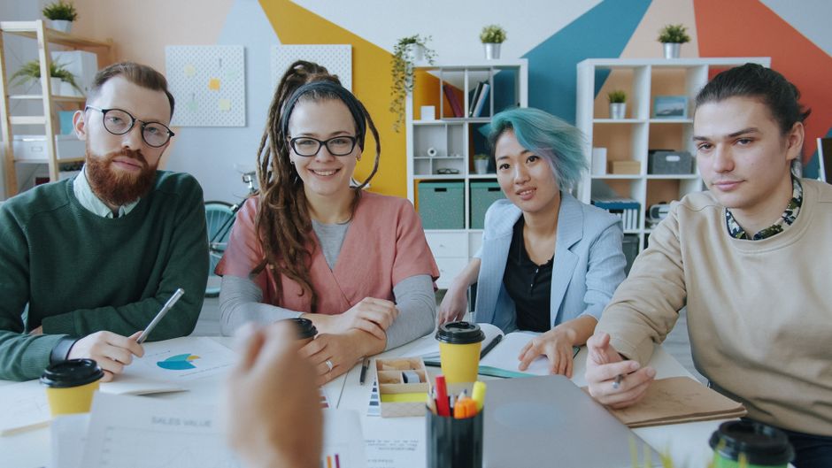 Un grupo diverso de profesionales colaborando en un entorno de oficina moderno, demostrando así su capacidad de trabajo en equipo.