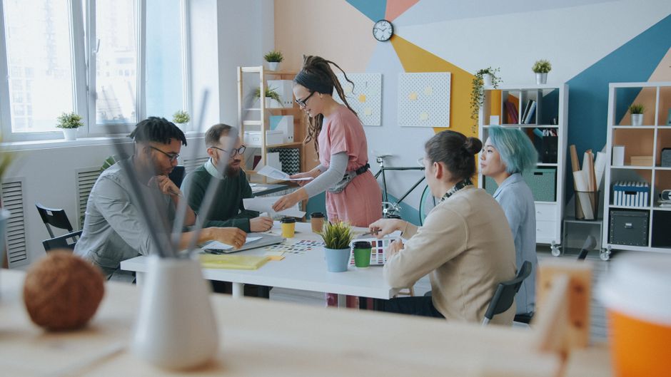 Entorno de oficina moderno con un equipo diverso que colabora y comparte ideas con entusiasmo.