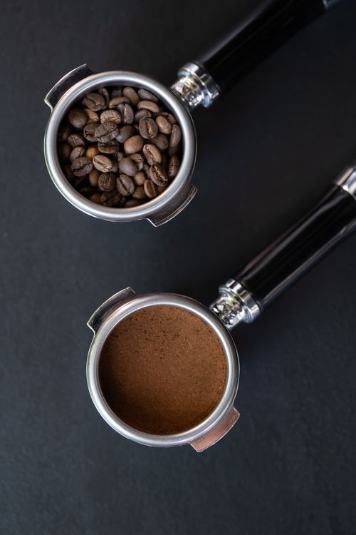 Free Top view of coffee beans and ground espresso in portafilters. Stock Photo