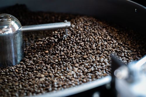 Free A detailed view of freshly roasted coffee beans inside an industrial roasting machine. Stock Photo
