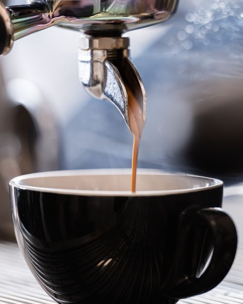 Free Close-up of espresso being poured into a stylish black cup, capturing the rich and aromatic coffee experience. Stock Photo