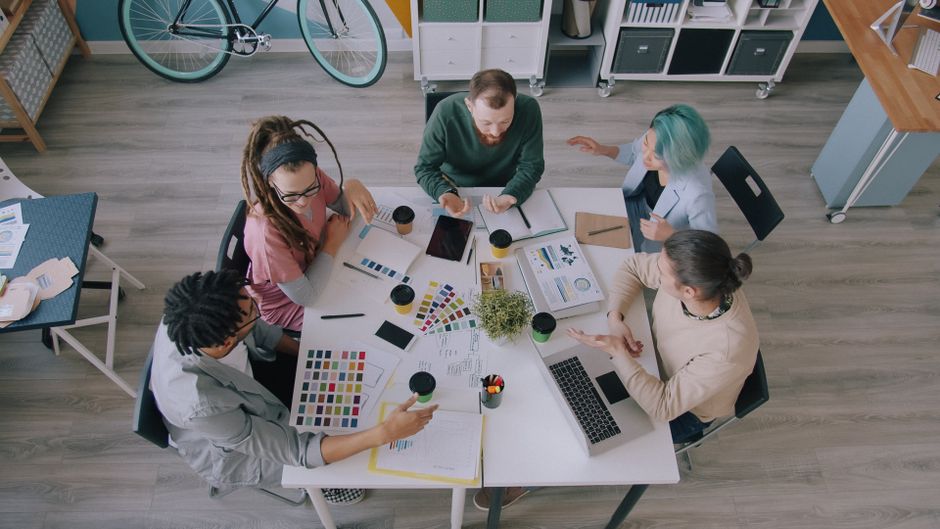 Diverse group of professionals collaborating on design ideas in a modern office setting.