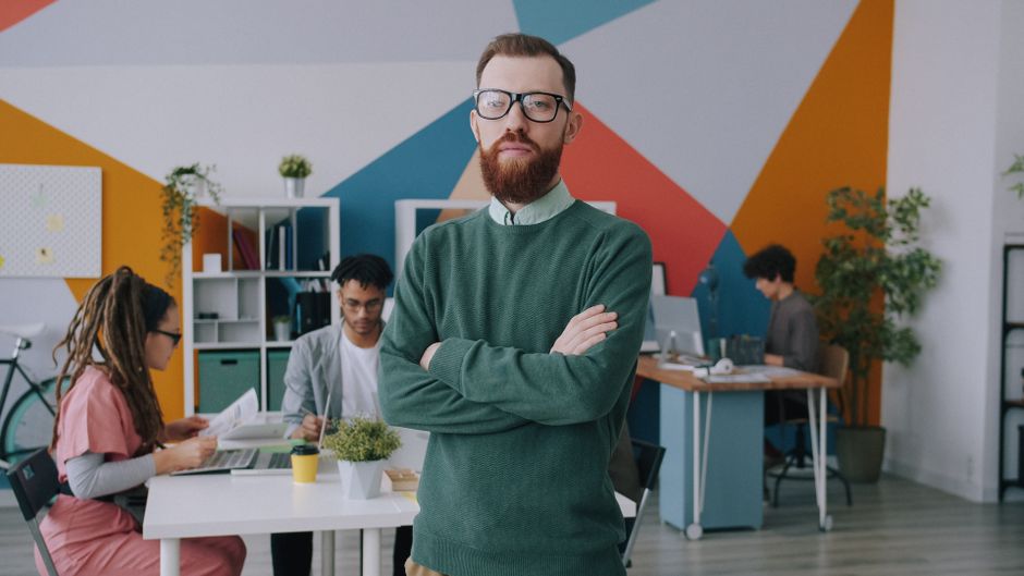 Jóvenes profesionales colaborando en un entorno de oficina moderno y dinámico, demostrando trabajo en equipo y creatividad.