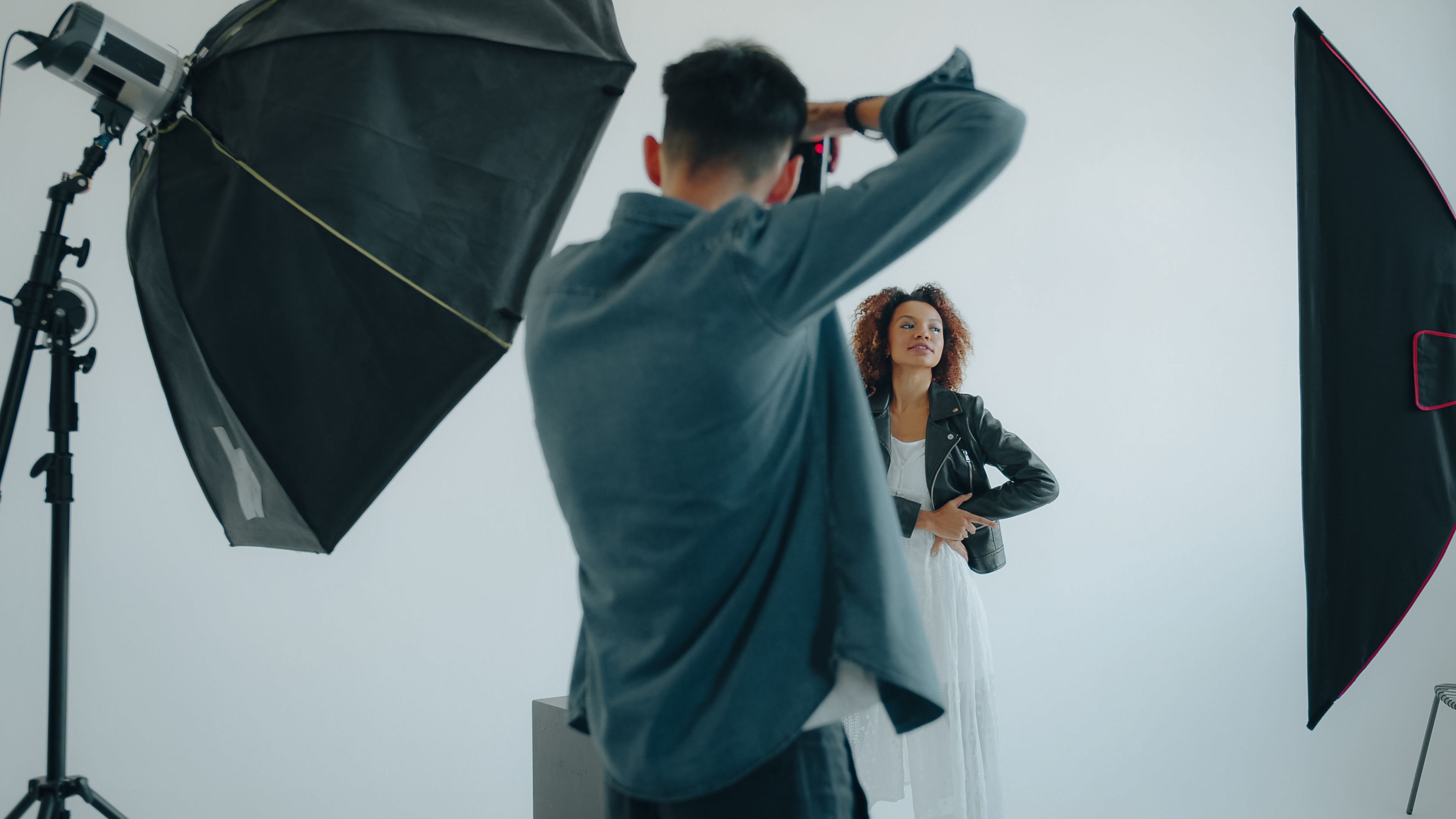 Photographer capturing a woman's portrait in a modern studio setup.