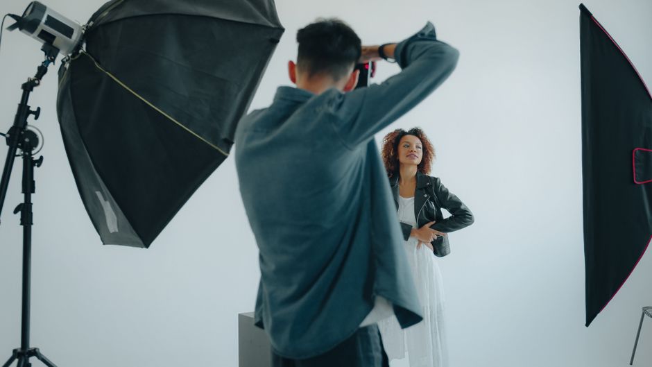 Photographer capturing a woman's portrait in a modern studio setup.