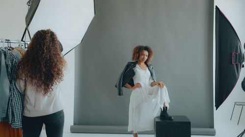 Free A studio photoshoot featuring a model in a white dress and leather jacket. Stock Photo