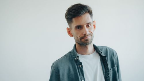 Free Portrait of a smiling man wearing a denim shirt and white t-shirt, looking at the camera. Stock Photo