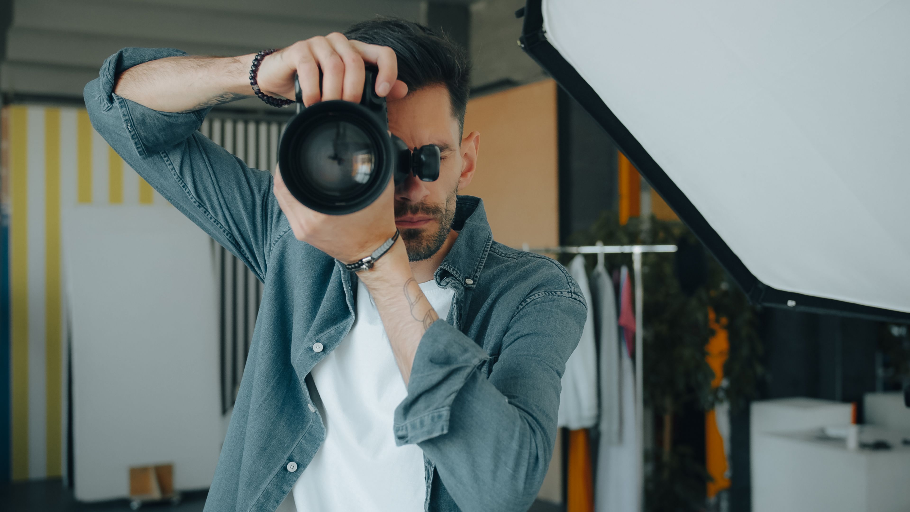 A male photographer capturing images in a modern studio setting.