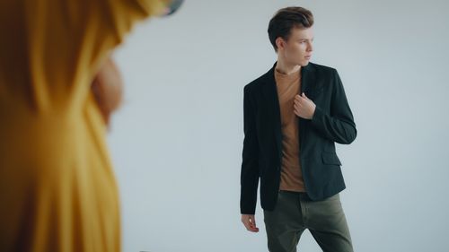 Free Confident young man wearing a black blazer and brown shirt, posing indoors with a thoughtful expression. Stock Photo