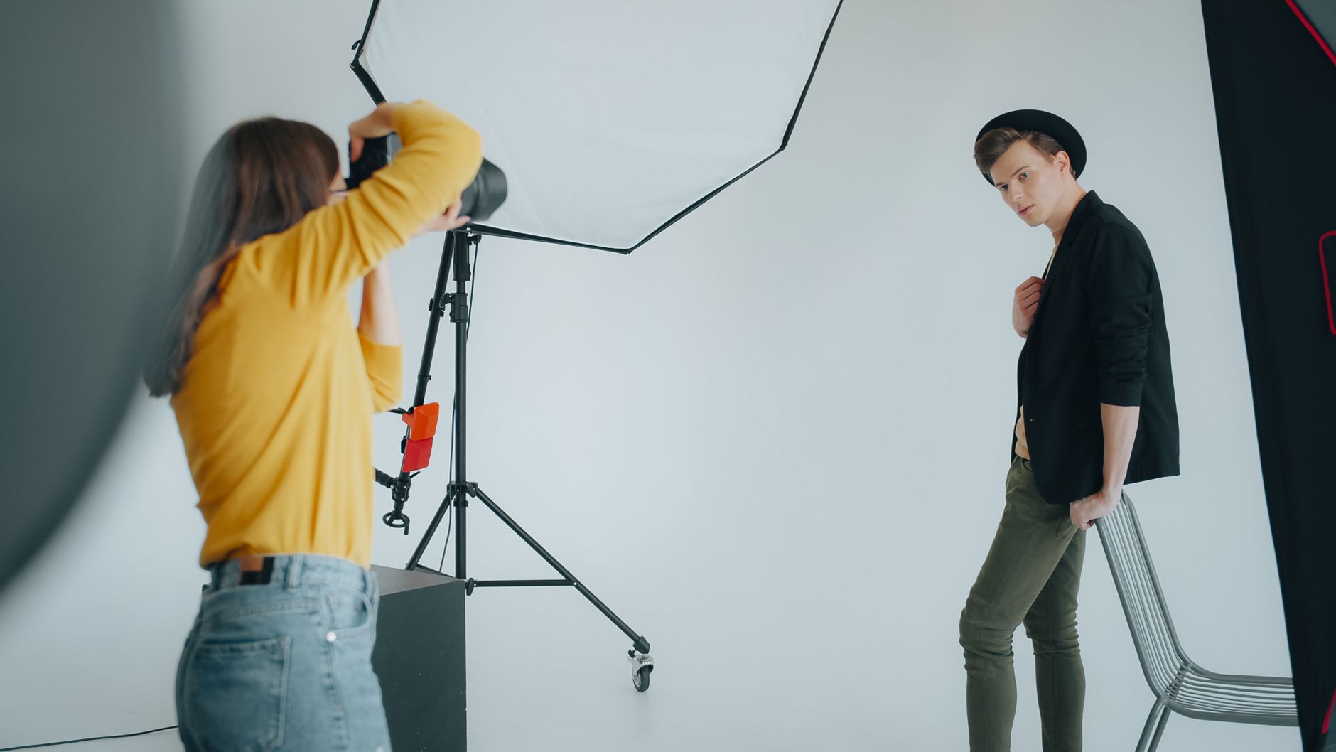 Photographer capturing a male model in a professional studio setting.