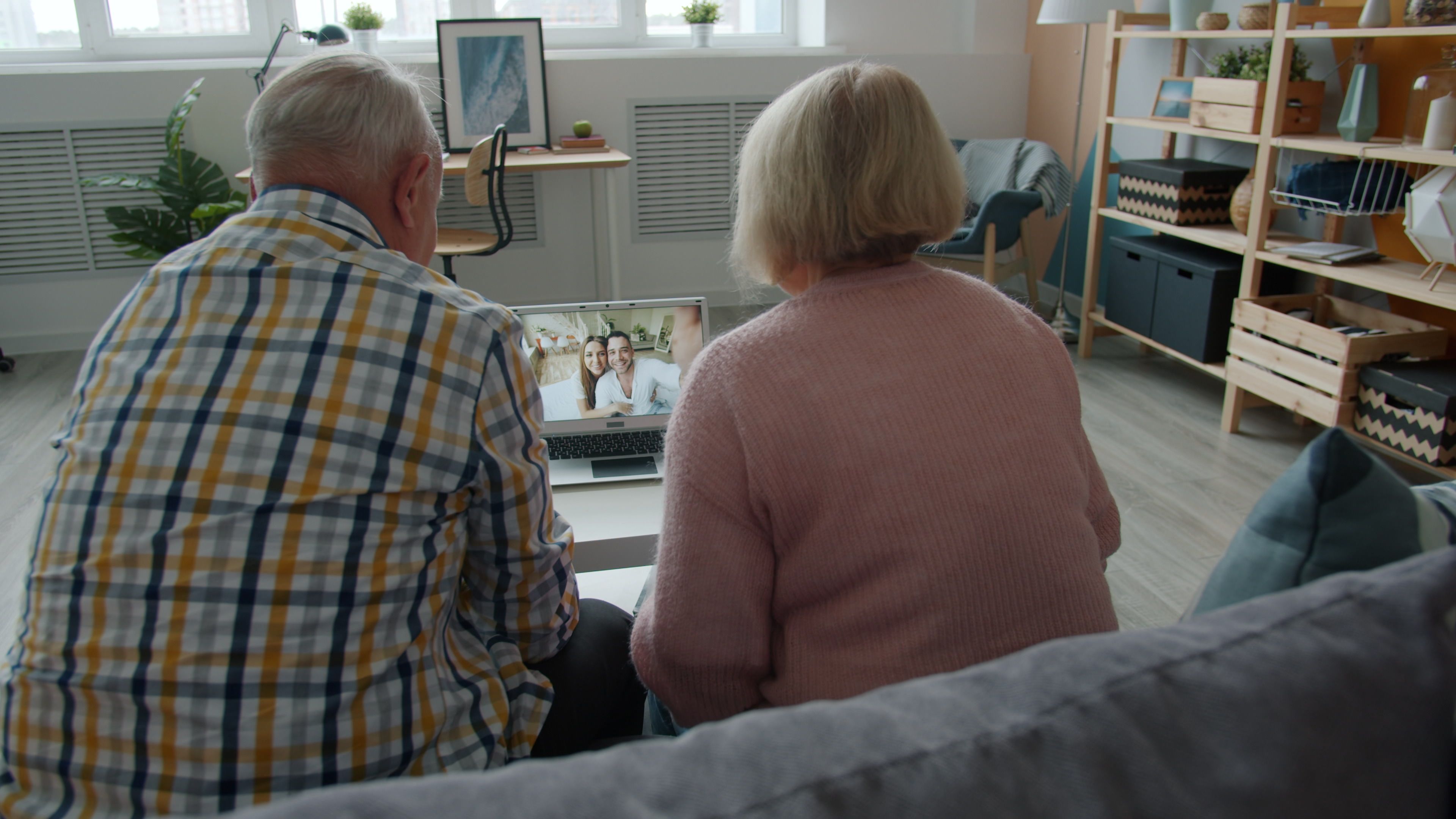 Elderly couple video chatting with family on laptop