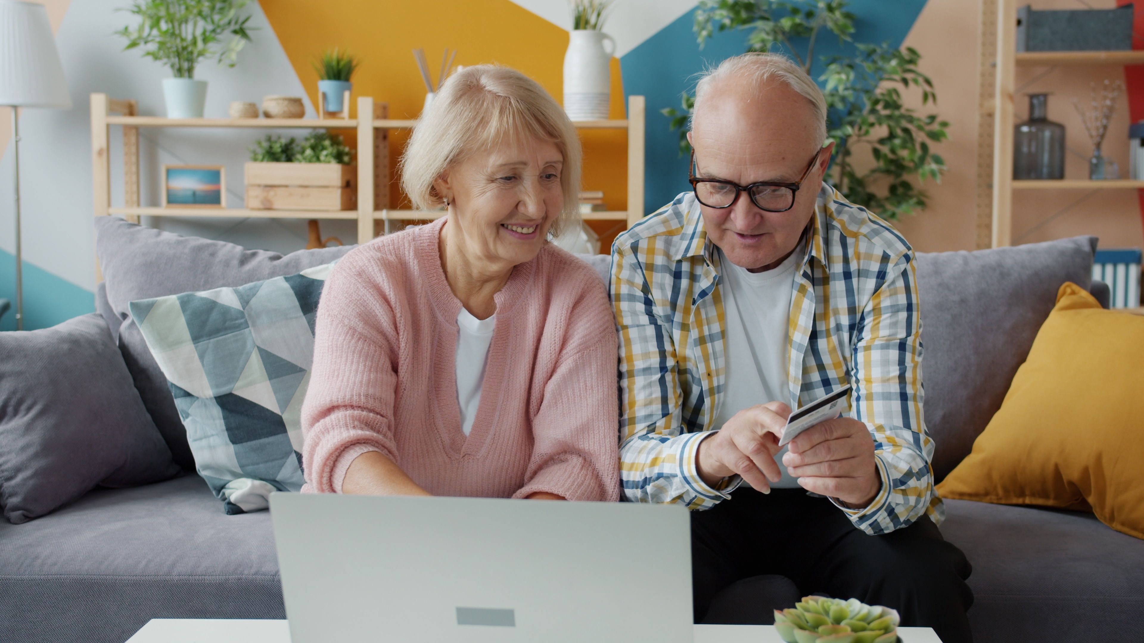 a family comparing JioHotstar subscription plans on a tablet while a football fixture list appears on a laptop