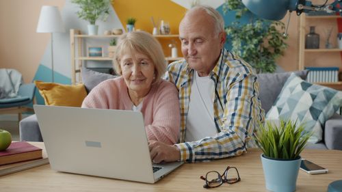 Free Elderly couple enjoying time on laptop in cozy living room with modern decor. Stock Photo
