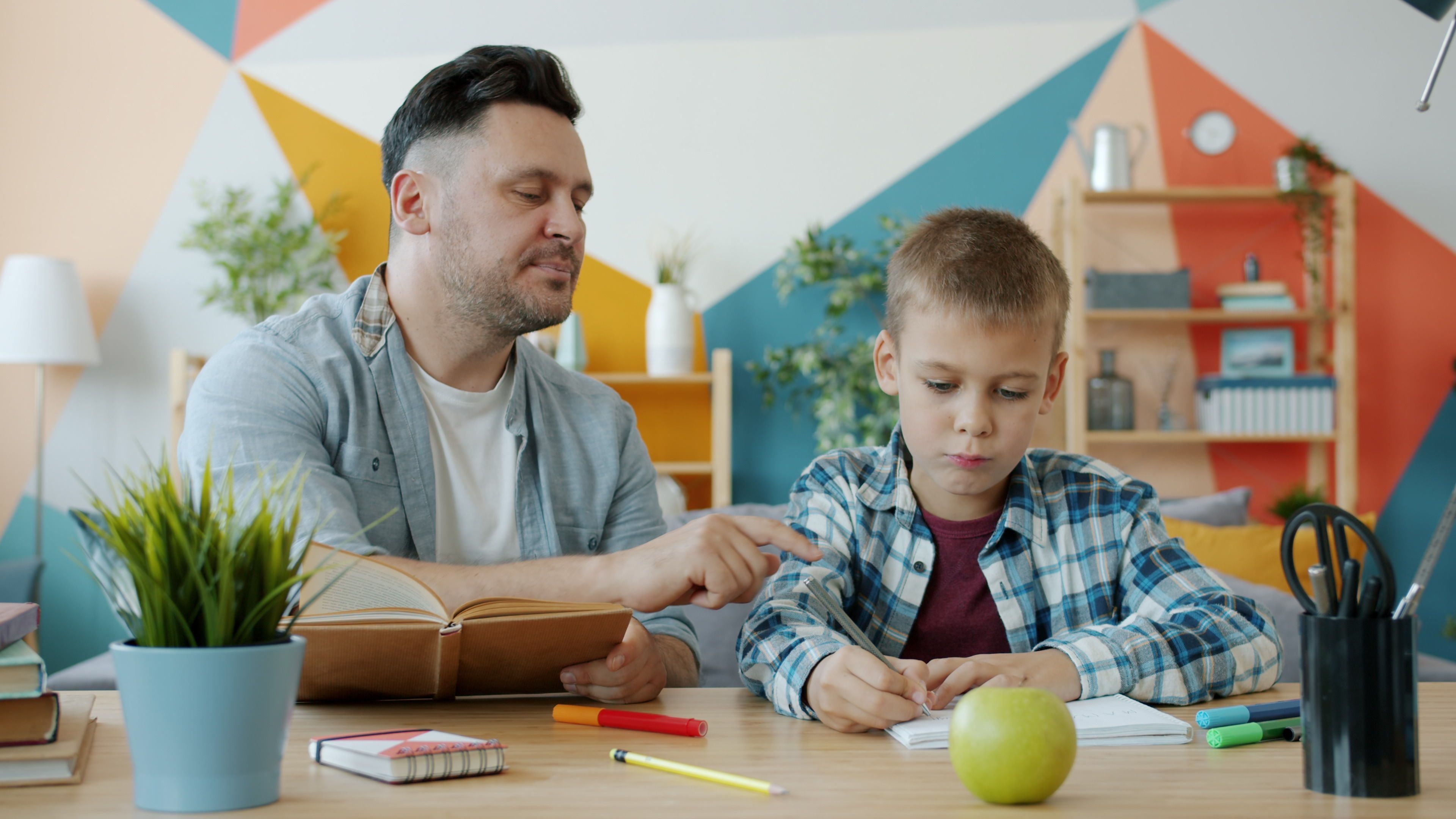 A parent helping a child with homework at the kitchen table, the everyday work behind falling chronic absenteeism in Clark County