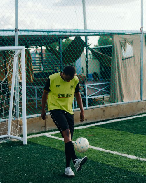 Free Young male athlete practicing soccer alone on an outdoor field in Dubai, UAE. Stock Photo
