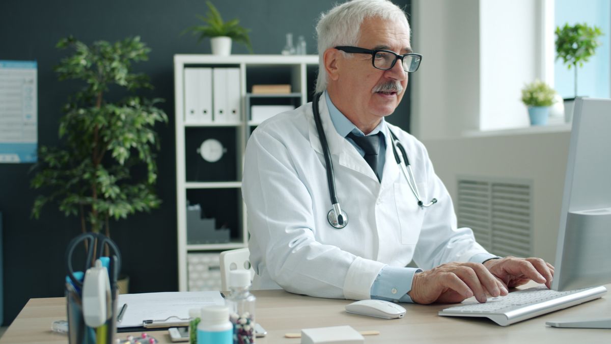 DHA and DoH: AI compliance in UAE healthcare Doctor working at a computer in a medical office