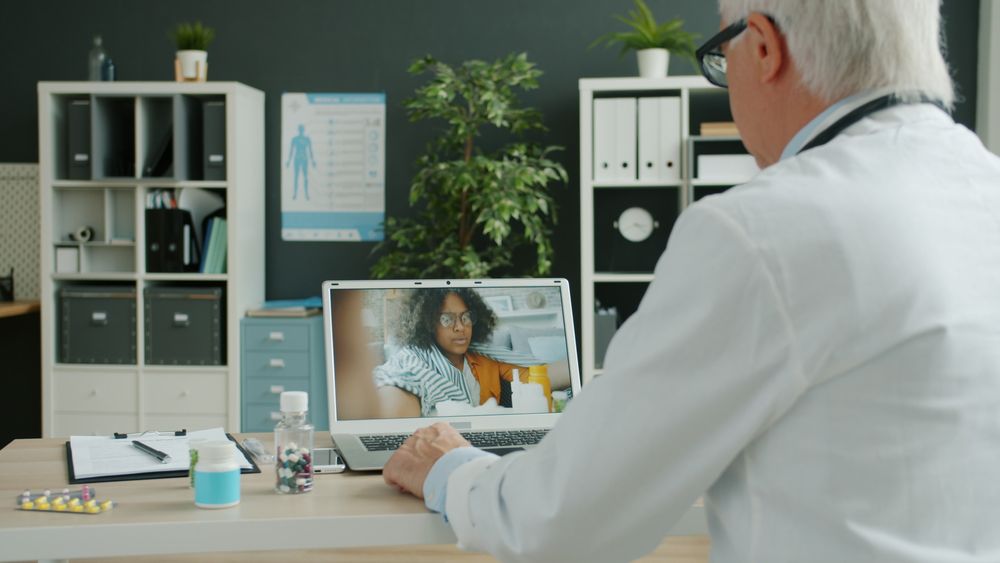 Doctor consulting a patient on a laptop