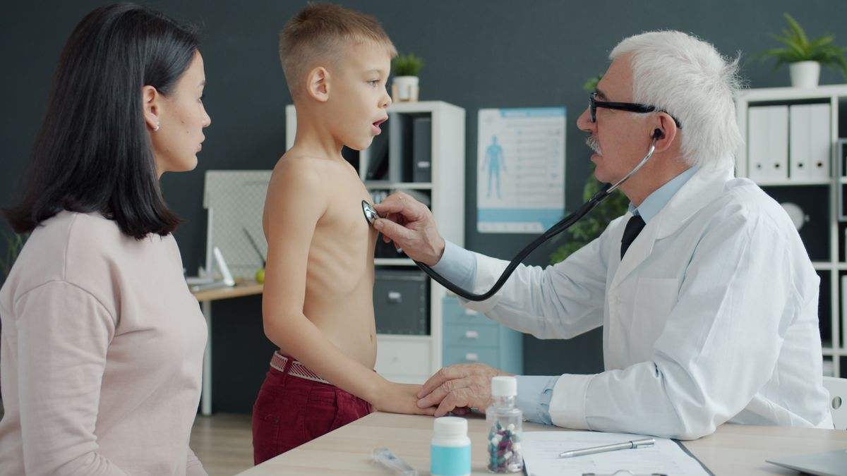 Doctor examining a child with a stethoscope during a back-to-school checkup