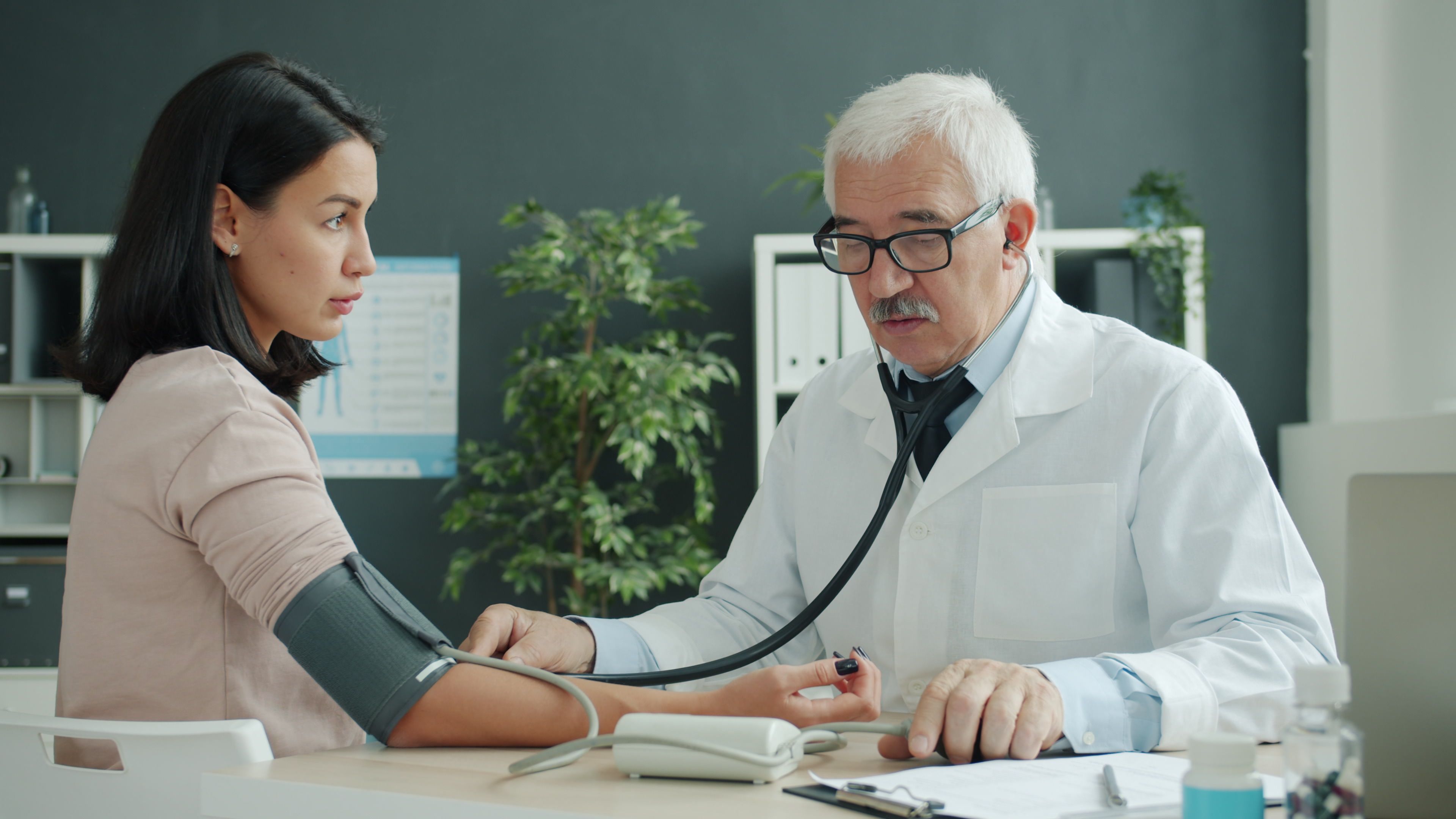 doctor checking patient blood pressure clinic