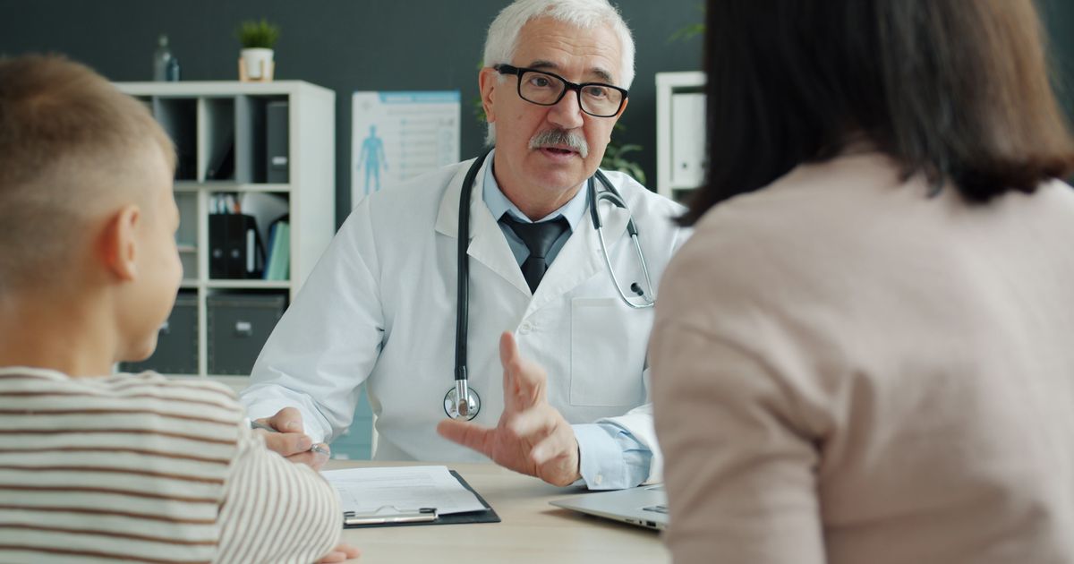 A doctor consulting with a couple during a medical appointment in a clinical office