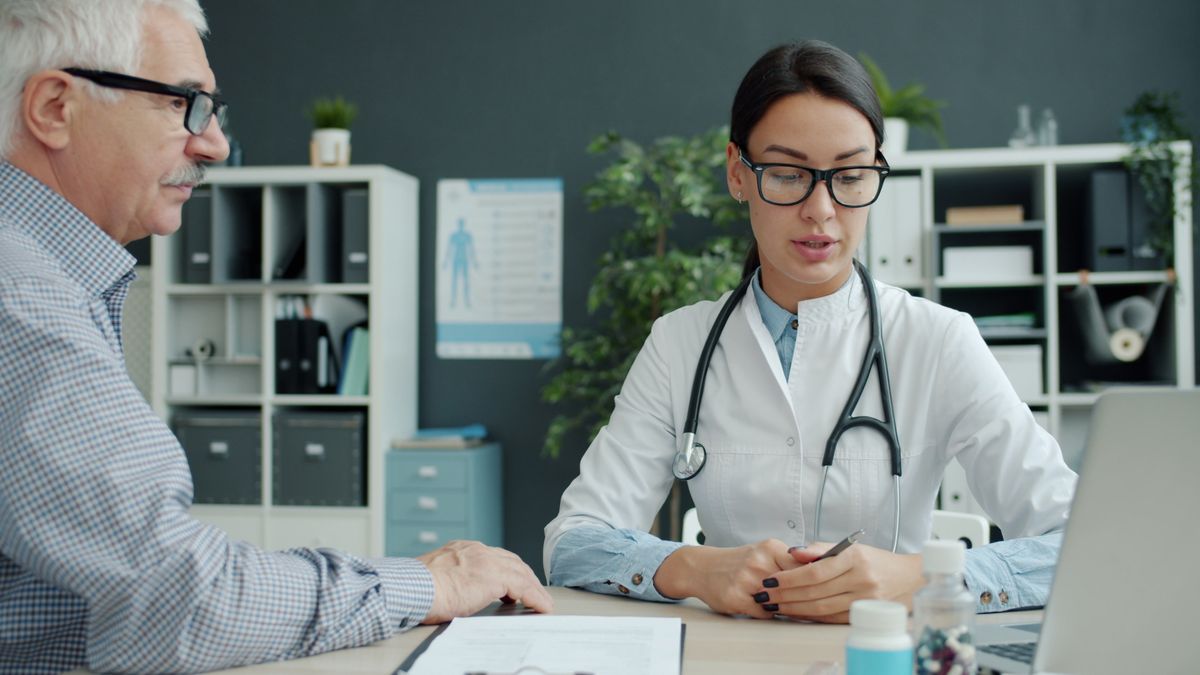 Family doctor consulting with an older patient in a primary care office