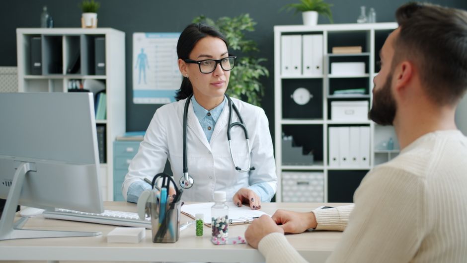 Doctor consults patient in modern clinic setting, discussing treatment options.