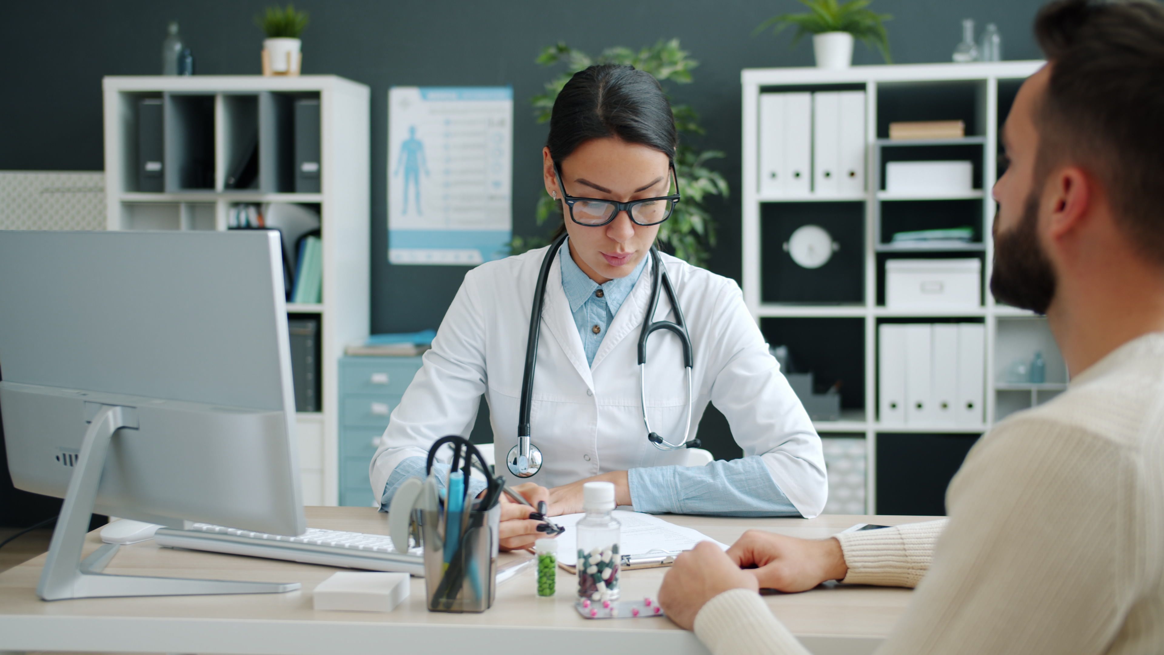 A female doctor consulting a patient in a modern office setting.